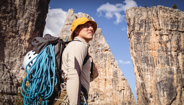 A young athlete man prepares for climbing, mountaineering outdoors.