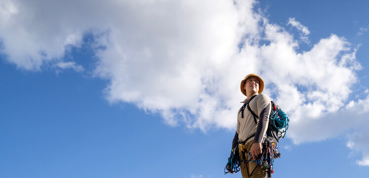 A young athlete man prepares for climbing, mountaineering outdoors.