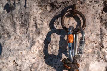 Climbing gear, carabiners, rope and anchor in  a rocky mountain closeup. © Zhanna