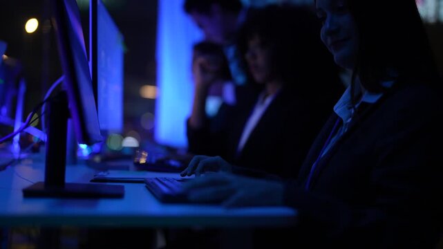 Inclusive business collective of experts including african american woman and asian male overseeing complex electronic systems and software code inside a modern futuristic corporate laboratory.