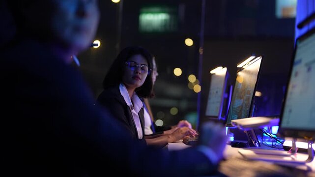 Inclusive business collective of experts featuring senior male executive and young female analyst optimizing automated trading systems and data flow in a sophisticated dark workspace hub.