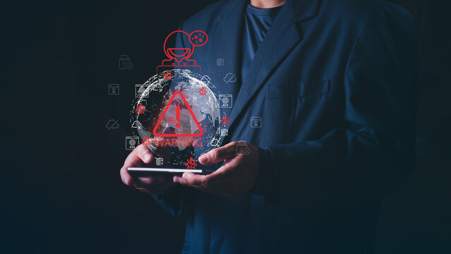 Concept for global cyber attack, data breach, network security threat, and digital virus protection service, Businessman holding smartphone with virtual red warning triangle and hacker.