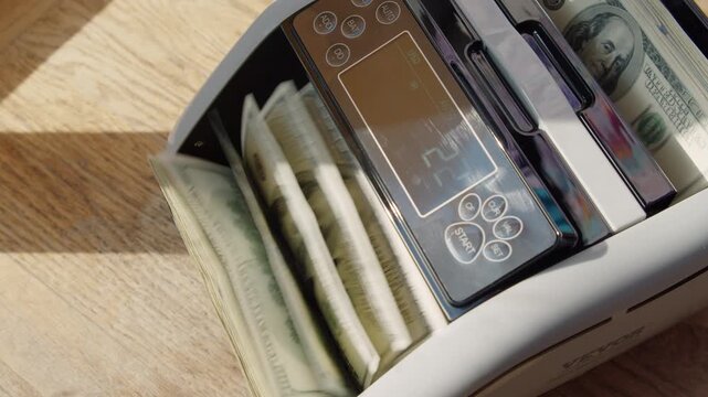 Glimpse into a charming workspace where a cash counting machine meticulously sorts and tallies bills, highlighting efficiency and precision in everyday finance
