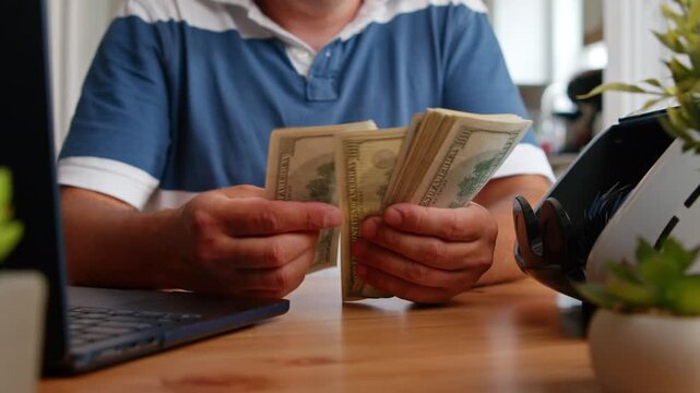 In a warm and inviting workspace, hands gracefully count stacks of cash, showcasing crisp bills glimmering in the afternoon sunlight. Focus on the calm process unfolds