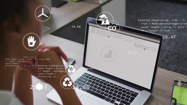 Woman leaning at laptop watching code loading and animating eco metrics icons for monitoring KPIs