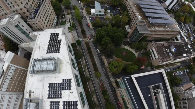 Aerial Downtown Rooftops Tennessee With Solar Panels, Modern Office Buildings, Treelined Medians, Pedestrian Plazas, Parking Structures And Green Courtyard, Sustainable Energy Focus In Urban
