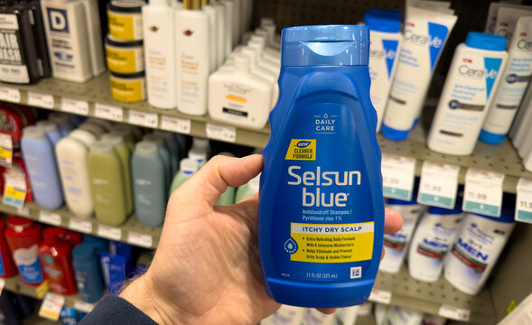 Selsun Blue Itchy Dry Scalp Shampoo Bottle Held in Department Store Aisle