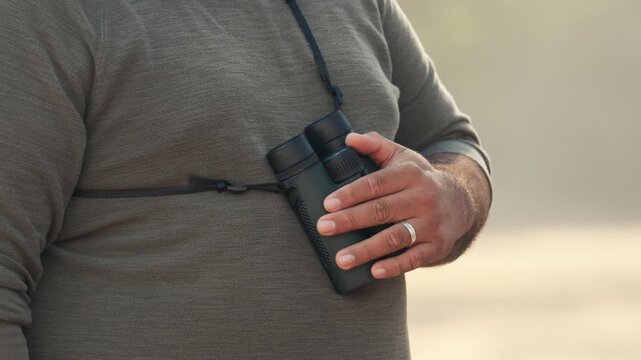 Hiker holding binoculars ready for birdwatching
