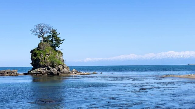 雨晴海岸より望む富山湾越しの雪の立山連峰と女岩