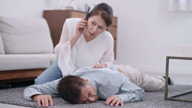 電話で救急車を呼ぶシニア女性