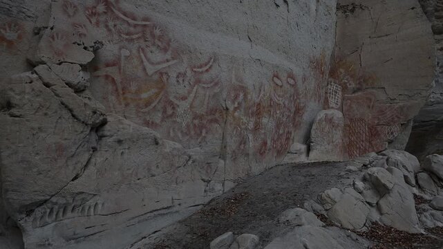 Ancient Aboriginal rock art on sandstone wall in Carnarvon Gorge, Australia, detailed indigenous paintings, cultural heritage site, historic storytelling, natural textures, iconic outback landscape.