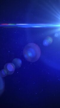 A bright blue light flare shines against a dark background with floating particles