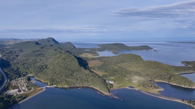 Aerial view of Bic National Park coastline, forest, campground and calm bay under blue sky. g.