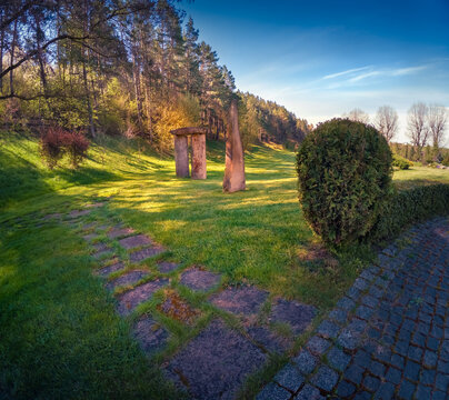 Amazinf morning scene of stone spire in the spring park. Wonderful morning view of green meadow in botanical garden. Beauty of nature concept background.