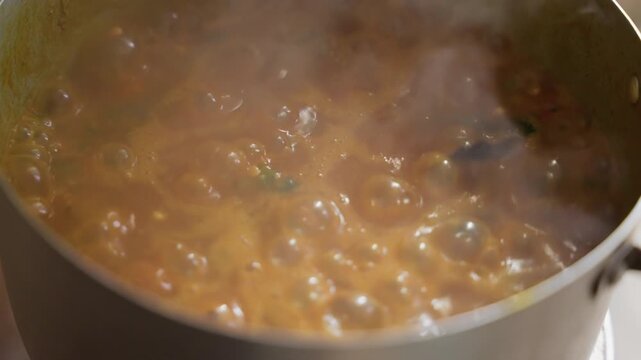 Wide bubbling stew in pot, spoon stirring thick sauce, dark utensil scraping sides, heavy steam cloud, metal saucepan on stovetop, chefstyle technique, active recipe preparation, rustic kitchen energy
