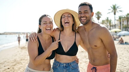 Obraz premium Three Friends Laughing Together on a Sunny Beach Vacation