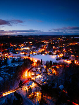 Aerial winter night view of Saint Jerome Quebec with snowy houses and glowing streets at blue hour. g.