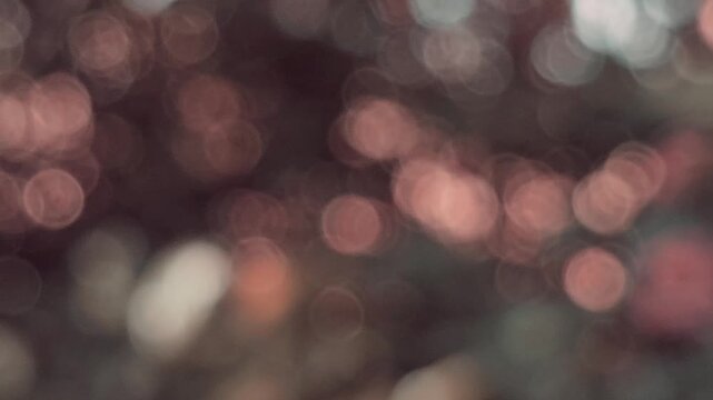 Warm bokeh lights in copper and amber tones create a soft, ethereal glow. The blurred circular patterns dance across a dark, moody background, autumn evoking a cozy, cinematic, and magical atmosphere.