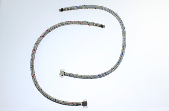Flexible hoses lie coiled neatly against a clean, white background. Metal fittings cap each end, ready for attachment, highlights the product's utility and durability, isolated on white background 