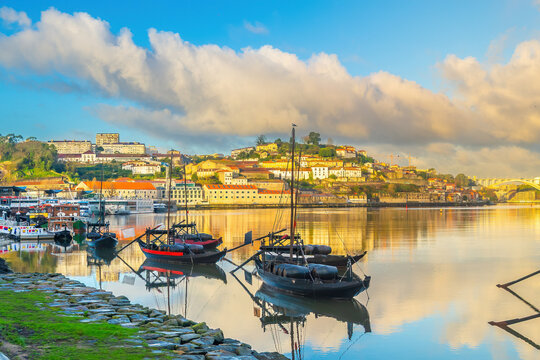 View of Porto's Ribeira district and traditional Rabelo boats on Douro River at sunset