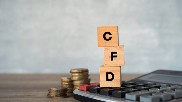 Contract for Difference CFD acronym on wooden cubes with calculator and coins.