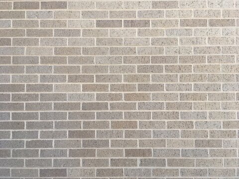 Modern light grey brick wall texture with uniform masonry pattern background