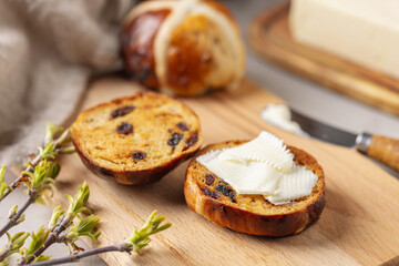 Delicious Easter Hot Cross Buns wiht Butter on wooden Board. Sweet Bread. Holiday Food