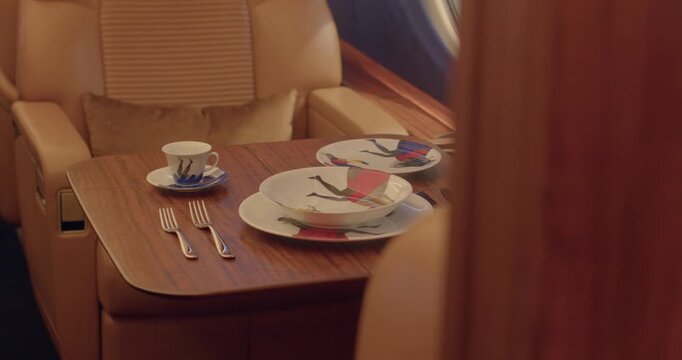 Elegant dining ambiance. Luxury table with scenic view. Sophisticated setting for refined meal experience. Comfortable jet seat with exquisite dinnerware by window light ambiance