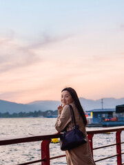Fototapeta premium Asian woman tourist watching the sunset over Dianchi Lake at Haihong Wetland Park in Kunming, Yunnan, China