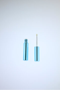 Minimalist cosmetic container blue tube with attached brush. Clean background enhances product's sleek design. Ideal for beauty, skincare, beauty cosmetic branding, isolated on white background. 