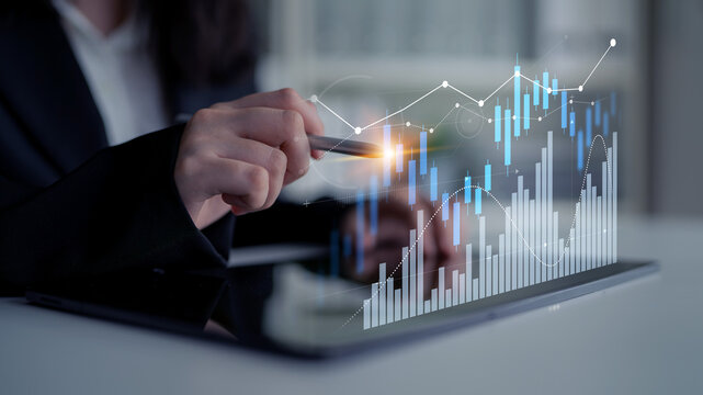 Businesswoman interacts with financial data on a digital tablet, showcasing a modern approach to analyzing market trends and investment strategies through innovative technology. Scalp