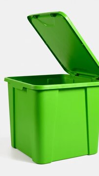 Bright green plastic bin with open lid on white background