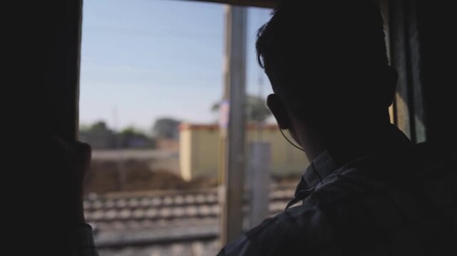 Train door view with railway tracks, Passenger looking outside moving train, Indian railway journey countryside view, Travel scene from train door stock video.