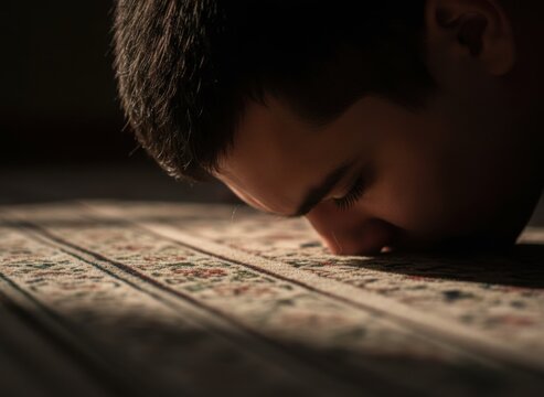 Man performing sujood prayer with forehead touching an ornate rug, intimate close up of religious devotion and spiritual worship with dark copy space for text