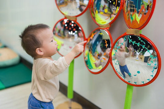 Baby playing with mirror inside playhouse