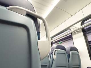 Obraz premium Empty modern train interior with blue seats and overhead storage