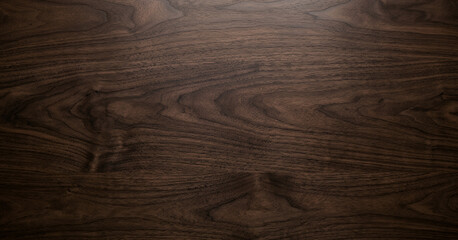 Close-up of dark walnut wood surface showcasing natural grain patterns and textures, ideal for backgrounds and design projects highlighting natural materials. © Wisnu