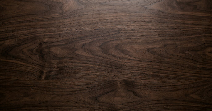 Close-up of dark walnut wood surface showcasing natural grain patterns and textures, ideal for backgrounds and design projects highlighting natural materials.