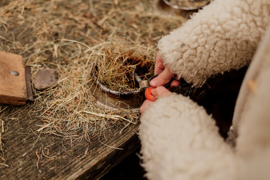 Child learning to make fire outdoors with natural materials