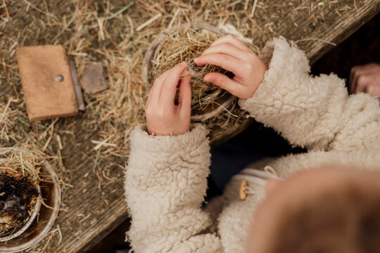 Child learning to make fire outdoors with natural materials