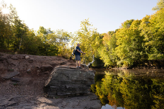 Adult man hiking in Michigan with trekking poles, Porcupine Mountain