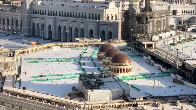 Morning view of the exterior of Masjid al-Haram in Makkah, showing the grand mosque architecture and surrounding sacred atmosphere