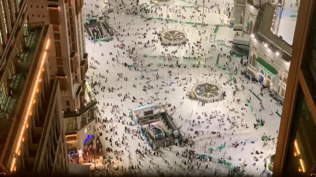 Timelapse view from above showing Umrah pilgrims walking across the courtyard of Masjid al-Haram in Makkah, capturing the busy yet spiritual atmosphere