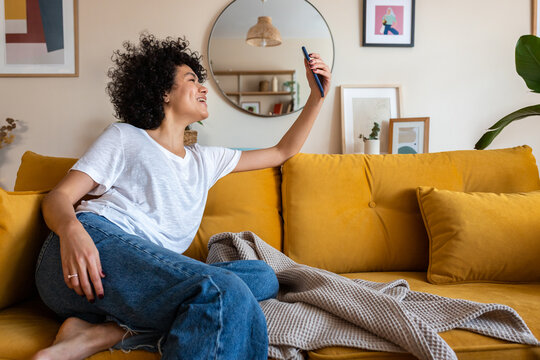 Happy woman recording smartphone video at home