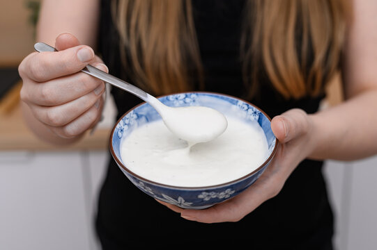 Thick Greek yogurt eaten up close, in a bowl with a spoon