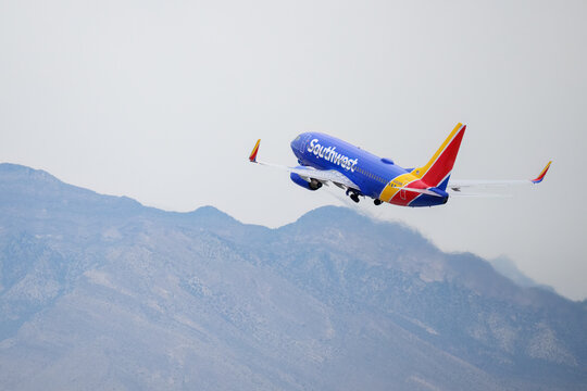Las Vegas, USA &ndash; Dec 23 2025: Southwest Airlines aircraft N483WN Boeing 737 flying over mountains with shimmer jet engine heat haze. Harry Reid Intl Airport.