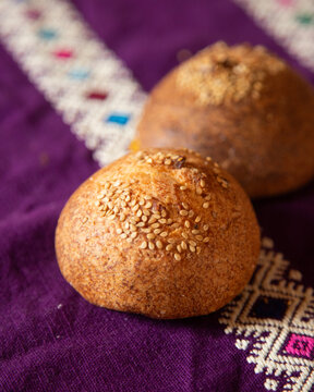 Pan de yema chiapas mexico traditional bread with sesame seeds on a wooden board