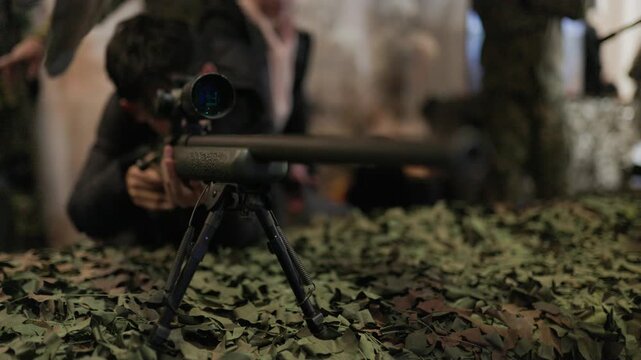 Military sniper aiming with a rifle during training
