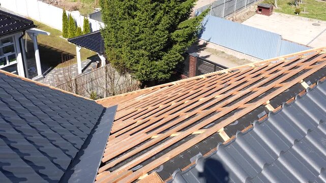 Roofing work. A dismantled roof, tiling work in progress. General view of the roof with rafters in place, work in progress.