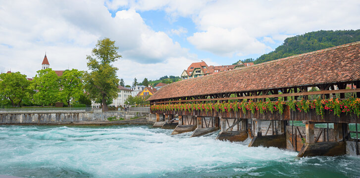Aare river old town Thun with wooden weir, geranium flowers, tourist resort switzerland